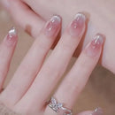 Close-up of a hand with clear nail polish and a silver ring on a blurred background, Obroi