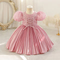 Pink children's dress on a mannequin against a decorative background, Obroi