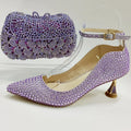 Purple high-heeled shoes with crystal embellishments and a matching handbag on a white background, Obroi