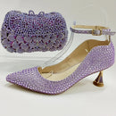 Purple high-heeled shoes with crystal embellishments and a matching handbag on a white background, Obroi