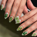 Close-up of hands with green floral nail art on a blurred background, Obroi