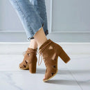 Brown open-toe heels with cut-out design worn with light blue jeans on a white floor, Obroi