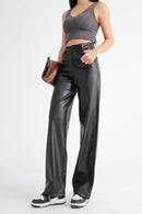 Person wearing black leather pants and a gray crop top on a white background, Obroi