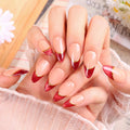 Close-up of hands with red and gold nail design on a blurred background, Obroi