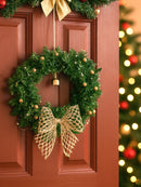 Christmas wreath with gold bow on a wooden door, festive lights in the background, Obroi