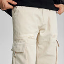Beige cargo pants with zippers and buttons on a light gray background, Obroi