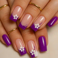 Nails with purple and white floral design on a beige background, Obroi