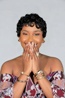 Woman with short black hair wearing jewelry against a gray background, Obroi