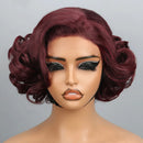 A short, voluminous wavy wig in a deep burgundy shade displayed on a mannequin head against a light gray background, with a black label reading, Obroi