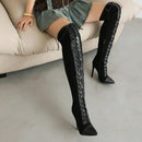 Person wearing black lace-up knee-high boots sitting on a beige couch, Obroi