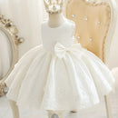 White lace dress with a large bow on a mannequin against a decorative background, Obroi