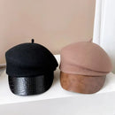 Two berets, one black with crocodile texture and one beige with crocodile texture, on a white surface, Obroi
