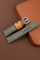 Green watch strap with orange buckle on a brown leather background, Obroi