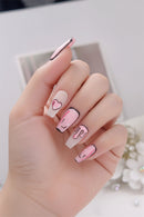 Hand with pink and white nail art on a blurred background, Obroi