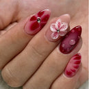 Obroi Nail art with red and pink design on a hand