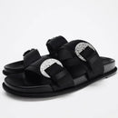 Black sandals with silver buckles on a white background, Obroi