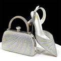 Silver clutch bag and high-heeled shoe with intricate designs on a white surface, Obroi