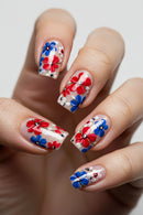 Nails with red, blue, and white floral design on a neutral background, Obroi