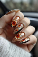 Hand with floral nail art in orange, black, and white on a blurred background, Obroi