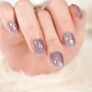 Close-up of a hand with glittery pink nail polish on a blurred background, Obroi