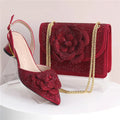 Red glittery shoe and matching handbag with floral design on a white background, Obroi