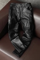 Black leather pants on a brown leather couch, Obroi
