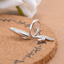 Silver ring with a unique design on a textured surface, Obroi