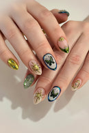 Close-up of hands with intricately designed nails featuring butterflies and other patterns, Obroi