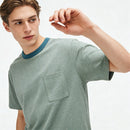 Man wearing a green t-shirt with a pocket on a white background, Obroi