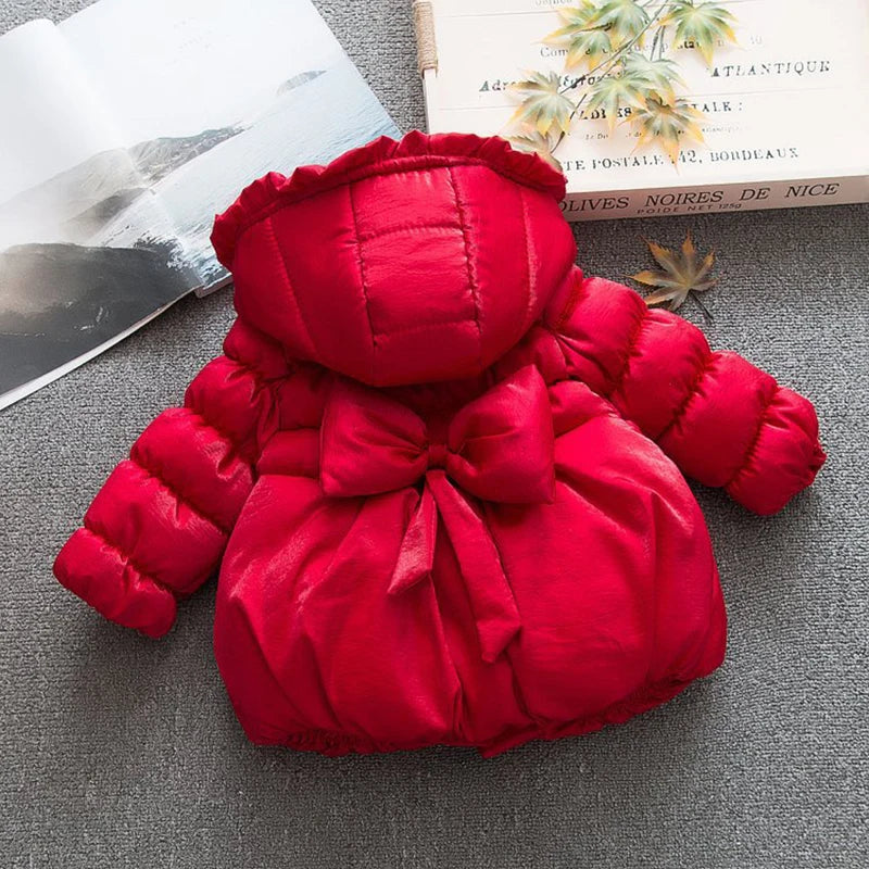 Red puffer jacket with a bow on a gray surface