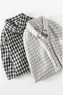 Two plaid shirts, one black and white, one gray and white, on a white background, Obroi