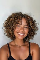 Woman with curly hair smiling against a plain background, Obroi