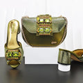 Green high-heeled shoes and matching handbag with gemstone details on a white background, Obroi