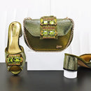 Green high-heeled shoes and matching handbag with gemstone details on a white background, Obroi