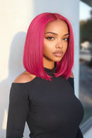 Woman with bright pink hair wearing a black off-shoulder top against a blurred outdoor background, Obroi