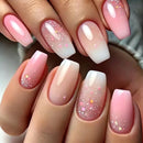 Obroi Close-up of hands with pink and white gradient nails with glitter.