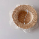 Woven straw hat with a white ribbon on a light gray background, Obroi