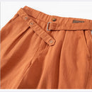 Close-up of brown pants with a belt and buttons on a white background, Obroi