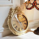 Decorative wall clock with intricate design on a white wall, Obroi