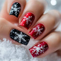 Nails with red, black, and white snowflake designs on a snowy background, Obroi