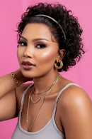 Woman with styled hair against a pink background, Obroi