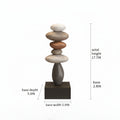 A stacked stone sculpture on a rectangular base with overlaid dimension labels showing base width, base depth, base height, stone stack height, and total height on a white background, Obroi