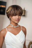 Woman with styled hair wearing a white top and decorative necklace, Obroi