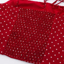 Red fabric garment detail with white polka dots and a central smocked panel, photographed close up on a white background, Obroi