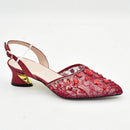 Red lace shoe with gold heel on a white background, Obroi