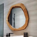 Wooden framed mirror on a bathroom wall with a sink and faucet in the foreground, Obroi