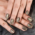 Close-up of hands with metallic gold nail polish on a fur background, Obroi