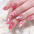 Close-up of hands with pink floral nail design on a soft white background, Obroi