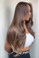 Woman with long, wavy brown hair wearing a white top and black Nike Pro shorts, Obroi
