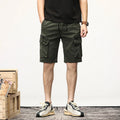 Person wearing green cargo shorts with a wooden crate and white wall in the background, Obroi